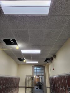 A hallway with lockers and a ceiling light.
