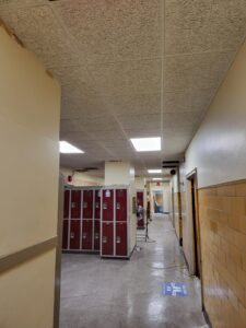 A hallway with lockers and a ceiling.