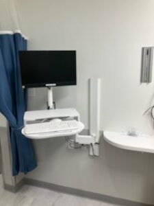 A hospital room with a computer and monitor.