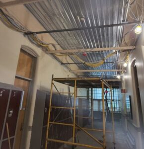 A hallway with a metal ceiling and some lockers.