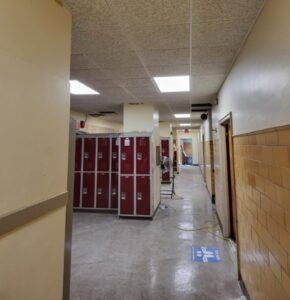 A hallway with lockers and a tile wall.