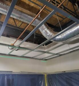 A room with ducts and pipes in the ceiling.