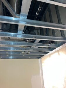 A room with metal beams and pipes in the ceiling.