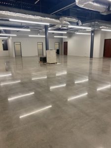 An empty office with a shiny concrete floor.