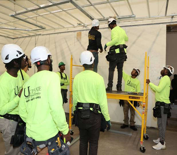 A group of construction workers standing in a room.