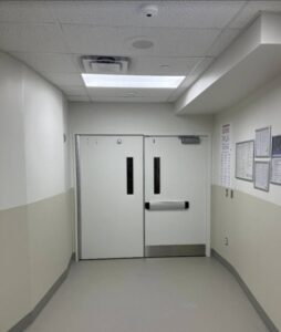 A hallway with a door leading to a room.