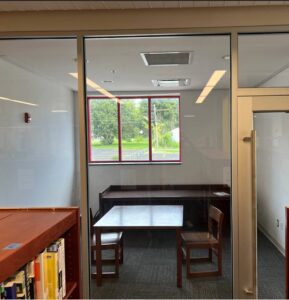 A room with a table and chairs and a glass door.