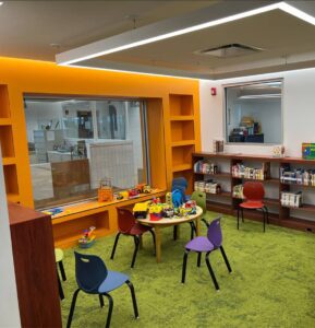 A children's room with colorful chairs and tables.