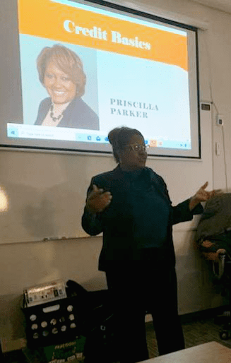 A woman giving a presentation in front of a group of people.