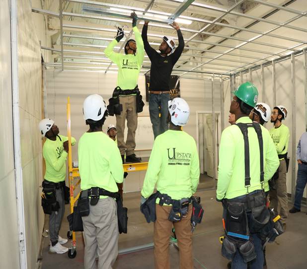 Group installing ceiling beams in construction site