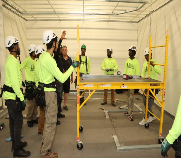 Construction workers assembling scaffolding indoors