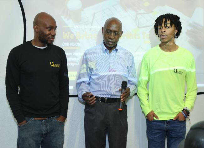 Three people speaking at an event